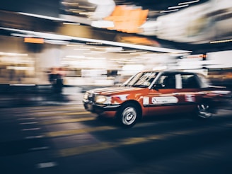 A social media style video thumbnail featuring a dynamic shot of a car in motion on a city street.