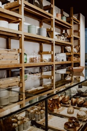 A cozy bakery interior with freshly baked goods displayed on wooden shelves.