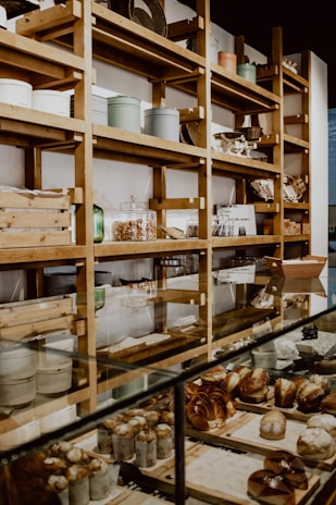 Cozy rustic bakery interior with wooden shelves filled with fresh bread and pastries.