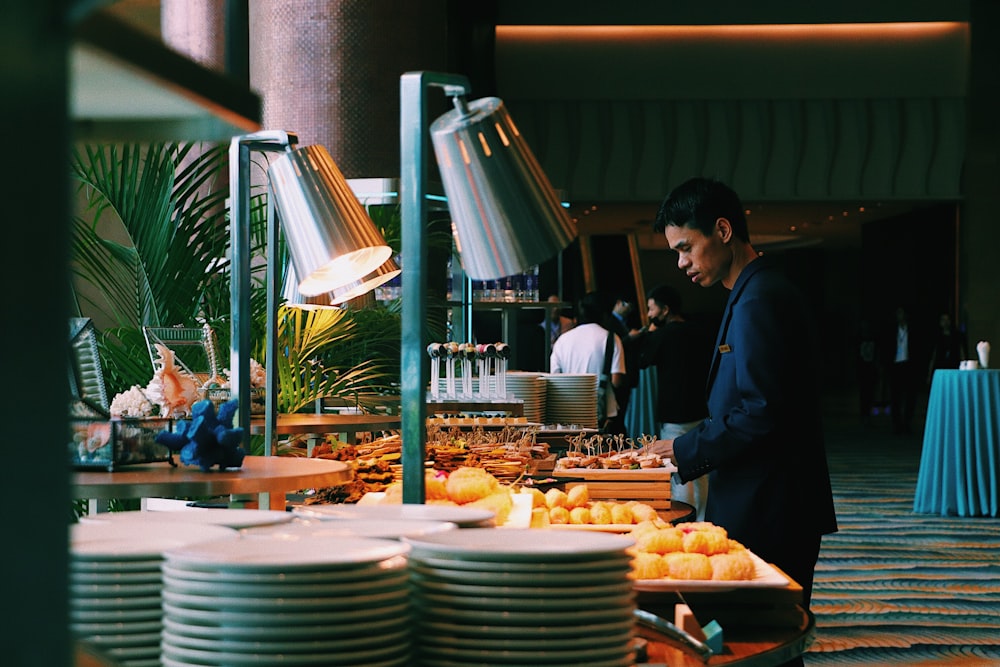 man pick some food at buffet table