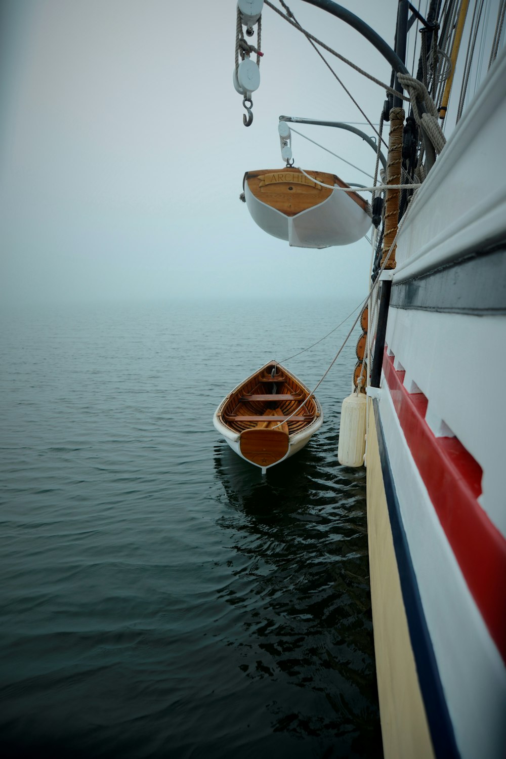 two white boats beside sailboat