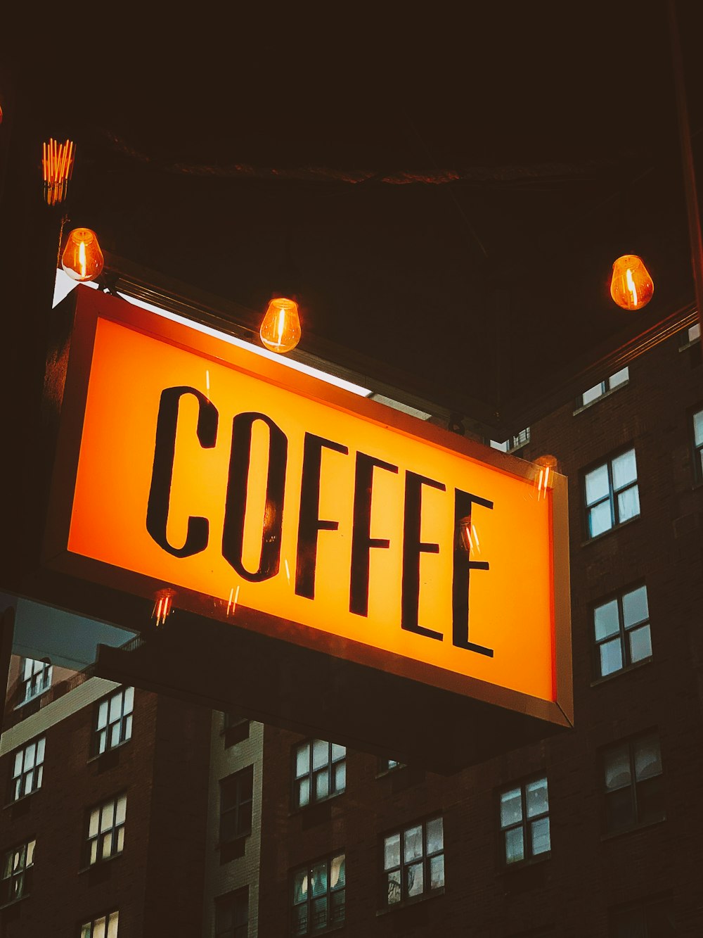 close up photo of Coffee building signage during nighttime