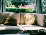 Brightly colored pillow inserts peeking out from elegant pillow covers in a sunlit room.
