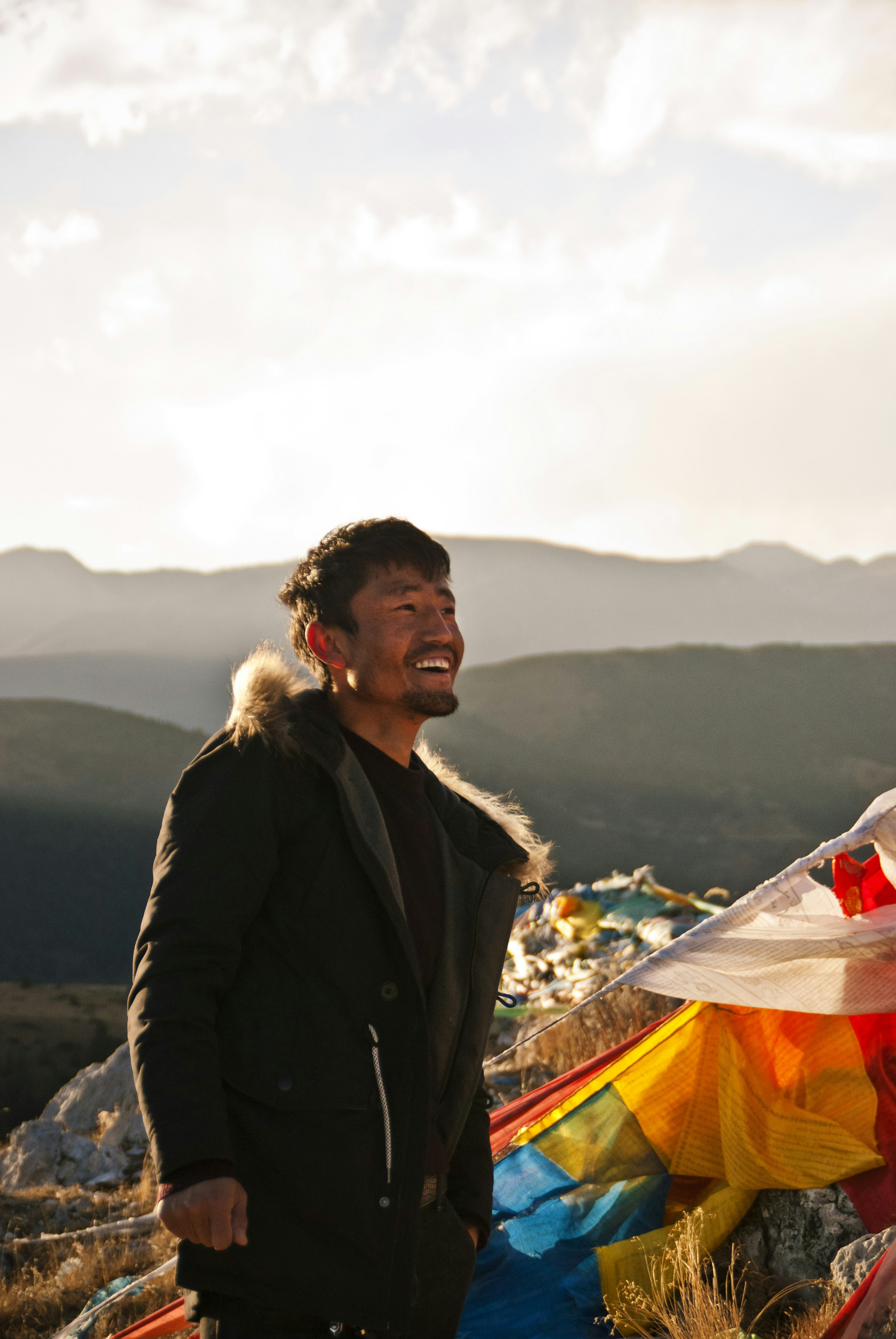 Founder of No T&C Travels smiling outdoors in Bir Billing with mountains in background, warm natural light