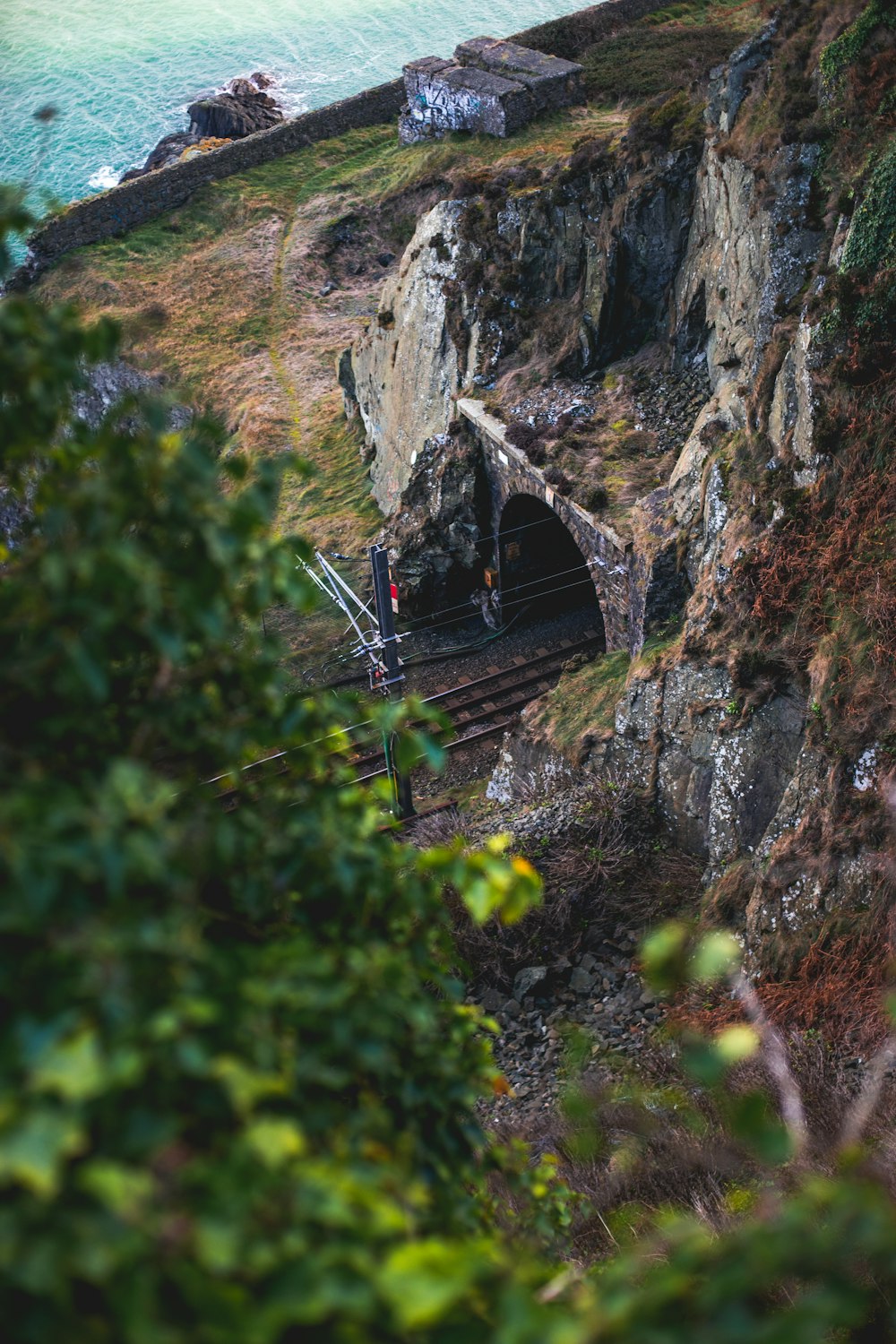 aerial photo of railway tunnel near sea during daytime