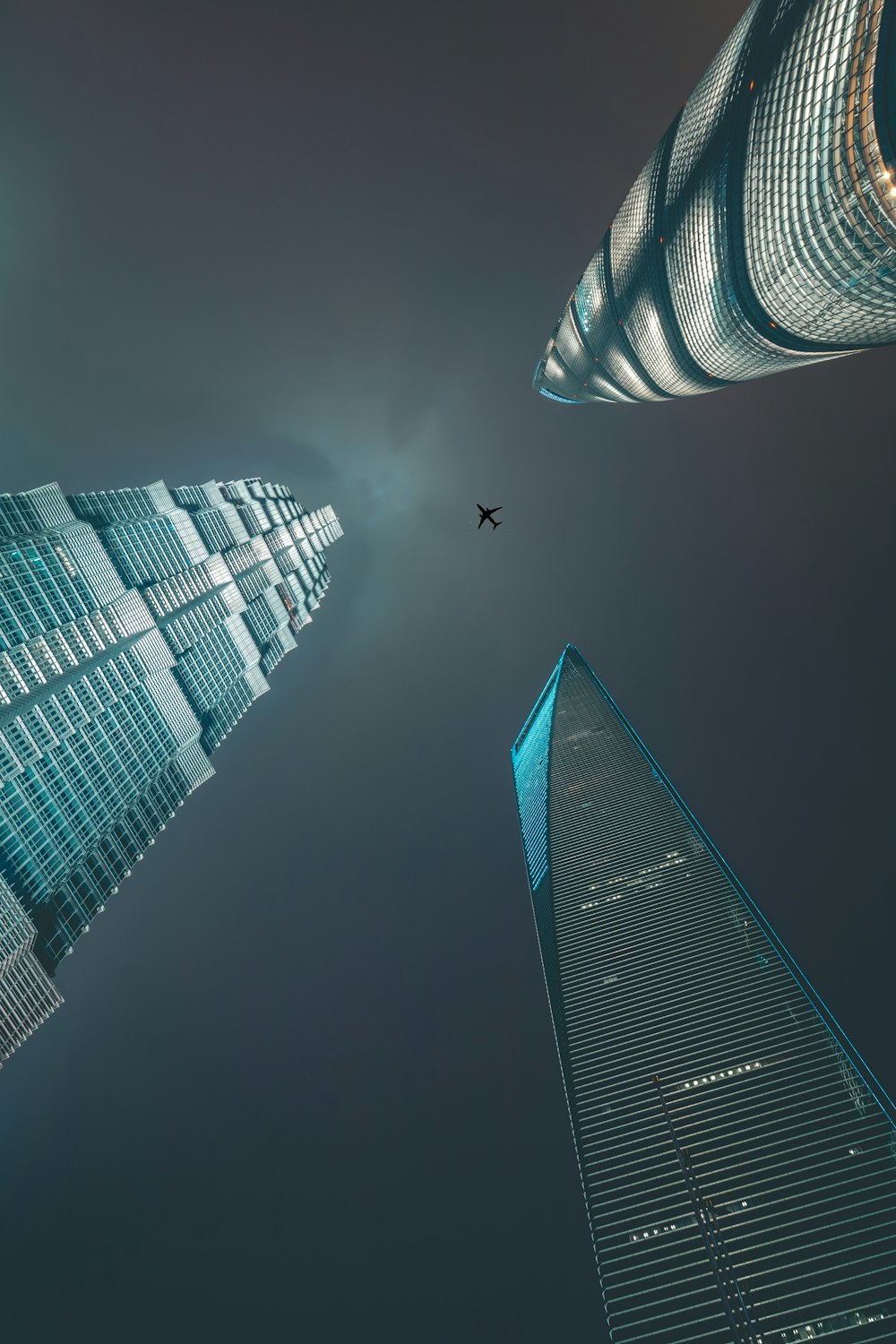 airliner flying over three high-rise buildings