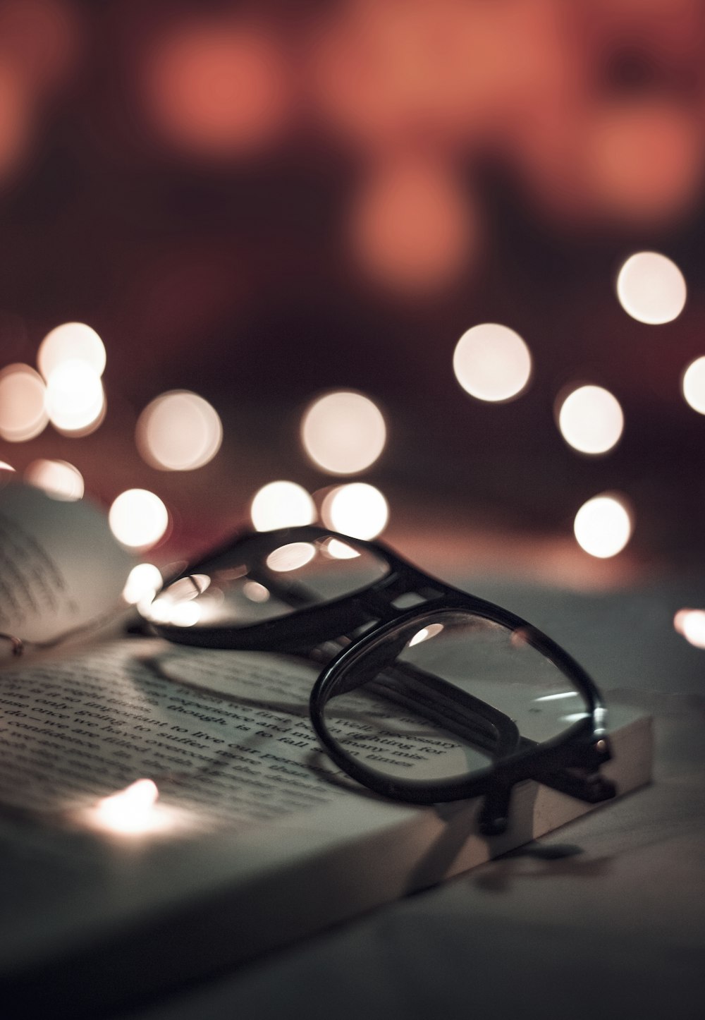 selective photo of black-framed eyeglasses on opened book