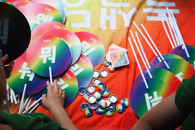 Close-up of official K-pop albums and merchandise arranged neatly with vibrant neon colors.