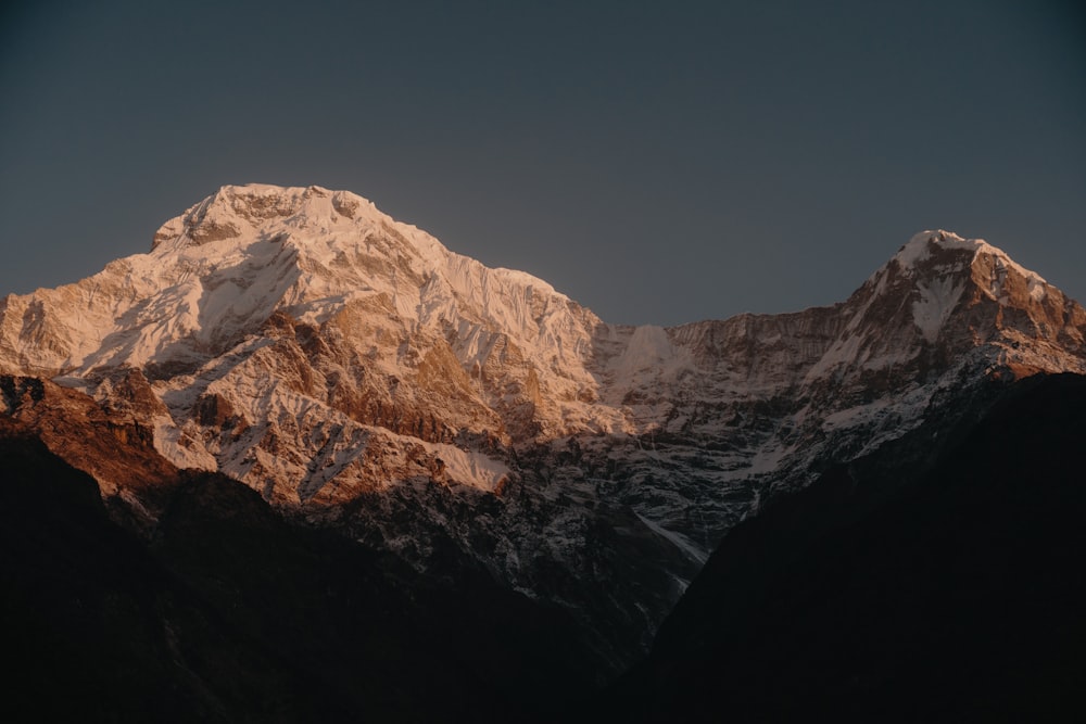 snow capped mountains under gray sky