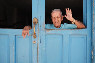 A friendly caregiver warmly greeting an elderly client at their doorstep.