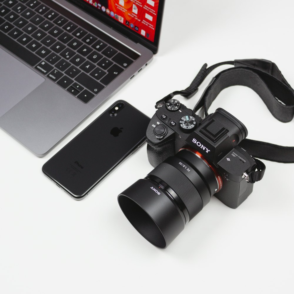 black DSLR camera and laptop