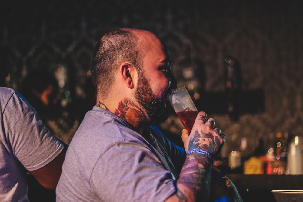 man drinking red liquid