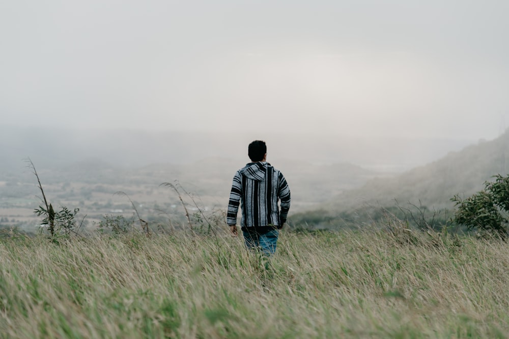 man walking on grass field