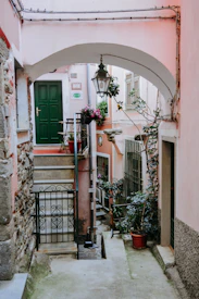 black wrought iron lantern hanging on arch above pathway