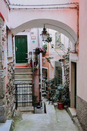 black wrought iron lantern hanging on arch above pathway