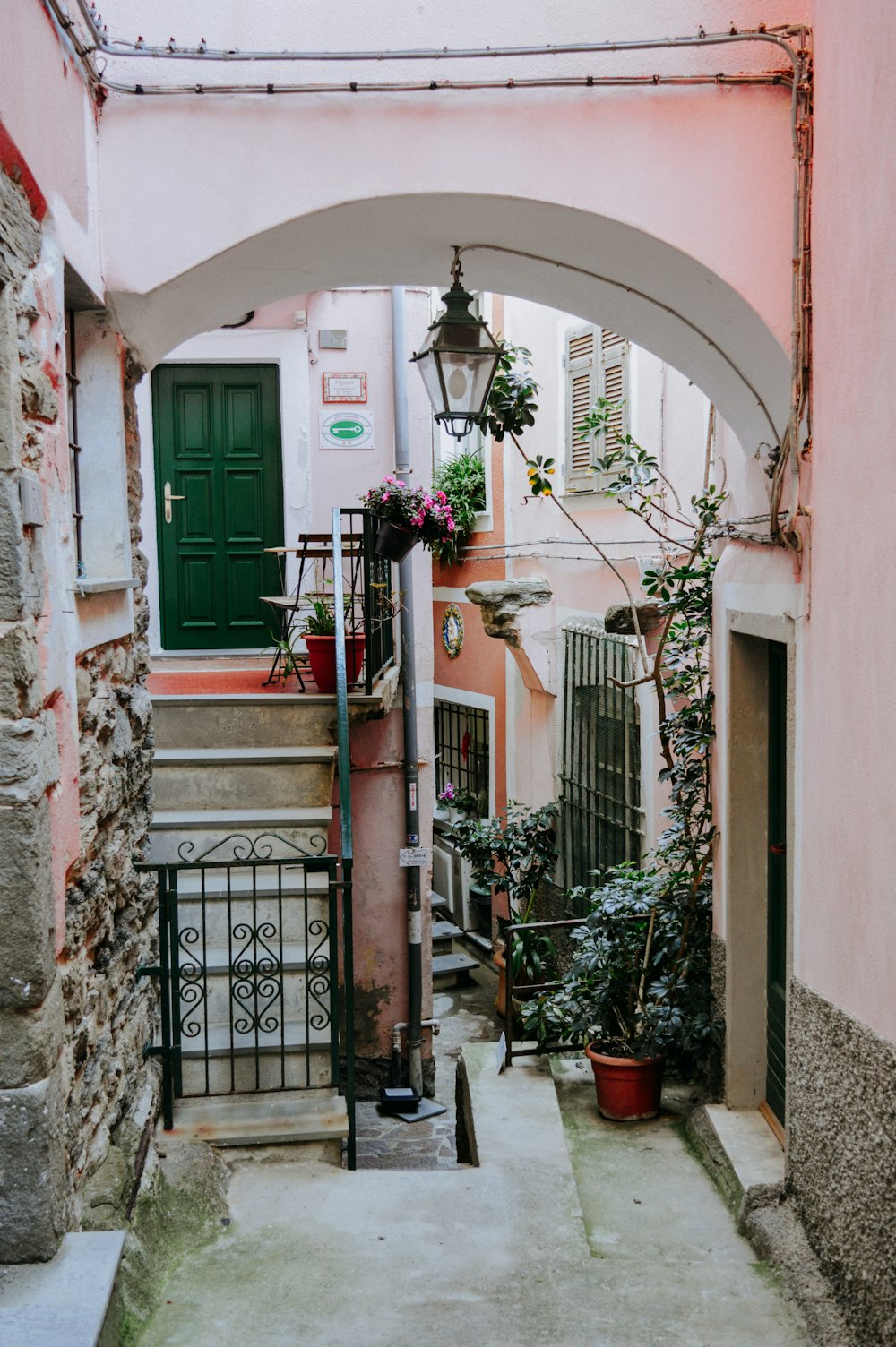 black wrought iron lantern hanging on arch above pathway