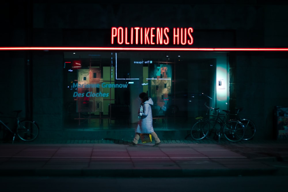 woman walking on street near Politikens Hus during nighttime