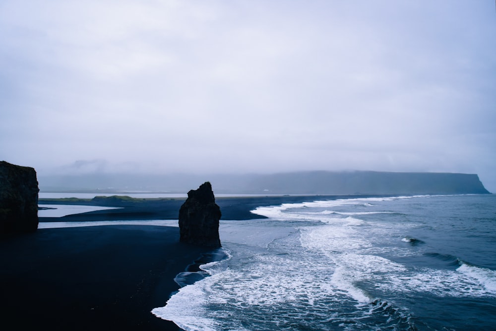 ocean waves crashing on rock formation