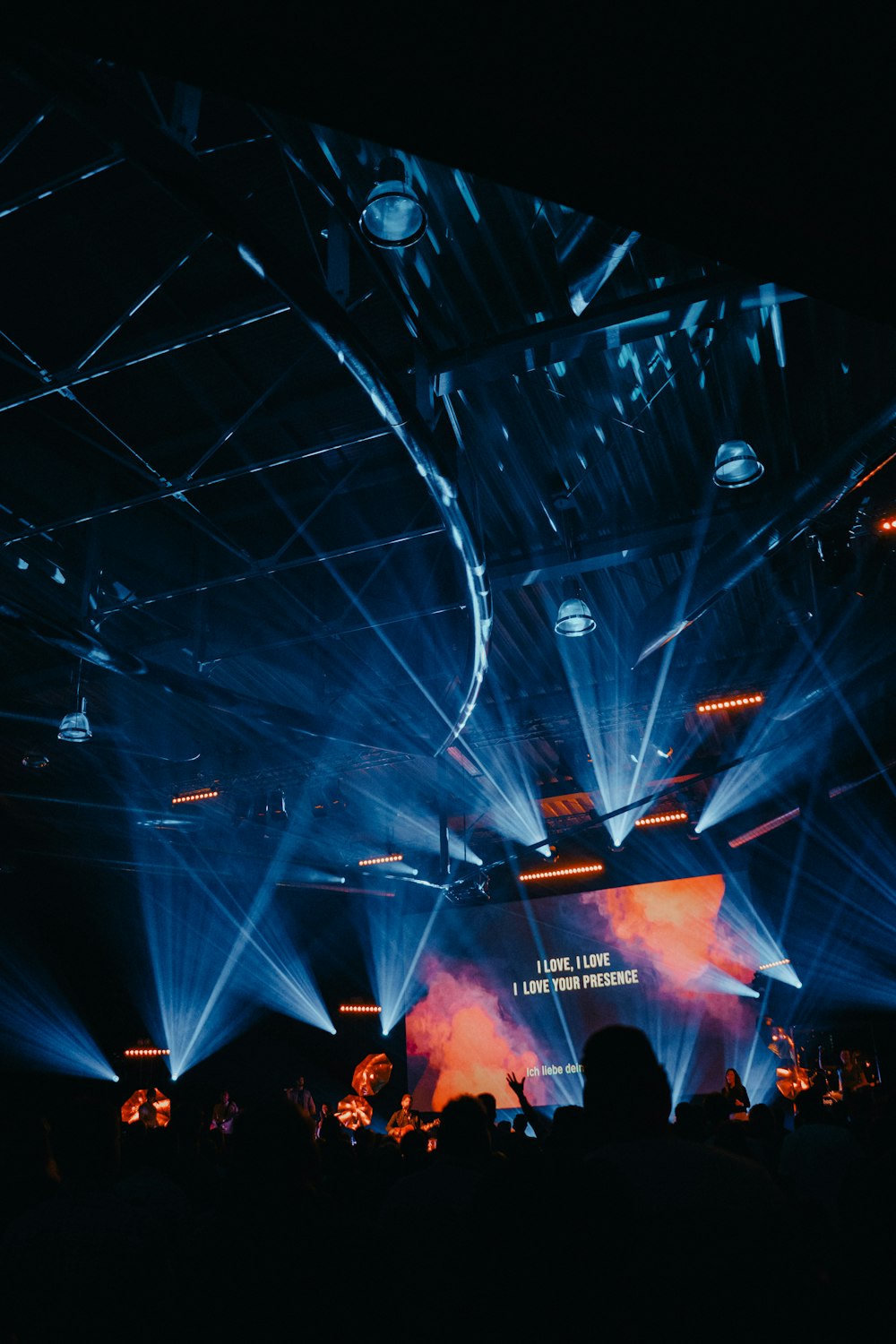 Pantalla del proyector que muestra texto en el escenario con luces