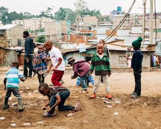 children playing on brown sand at daytime