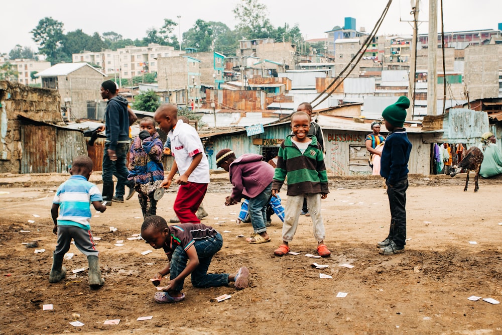 niños jugando en la arena marrón durante el día