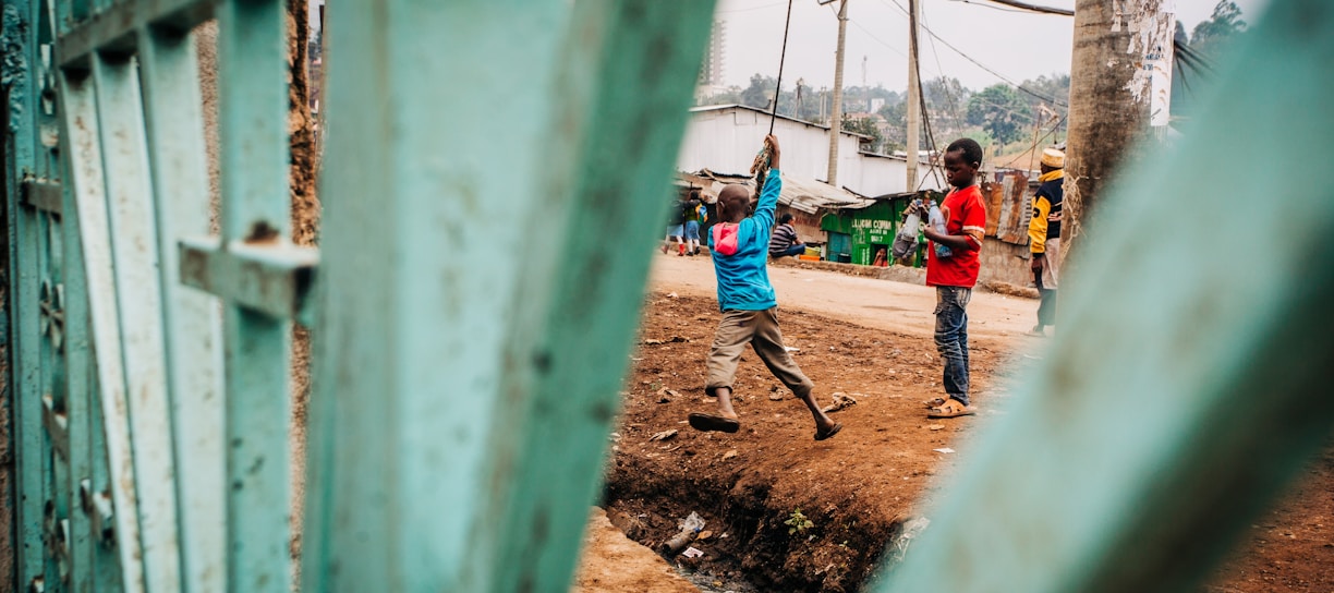 kids playing on cable by gate during daytime