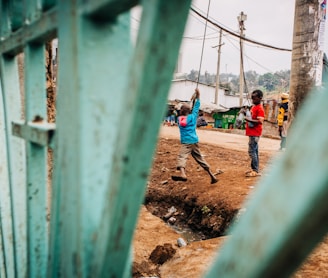 kids playing on cable by gate during daytime