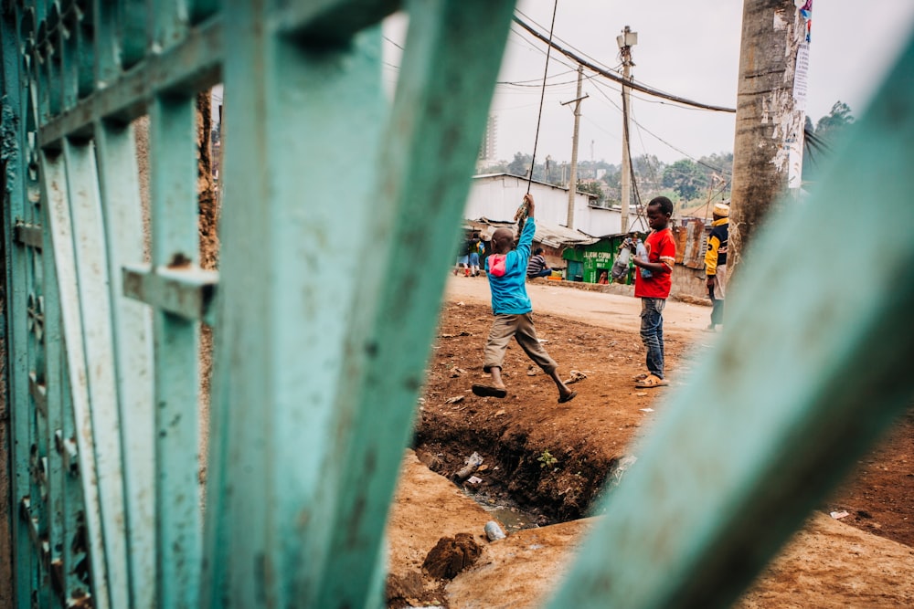 kids playing on cable by gate during daytime