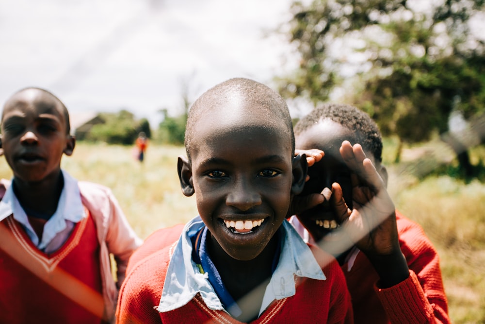 three boys smiling during daytime