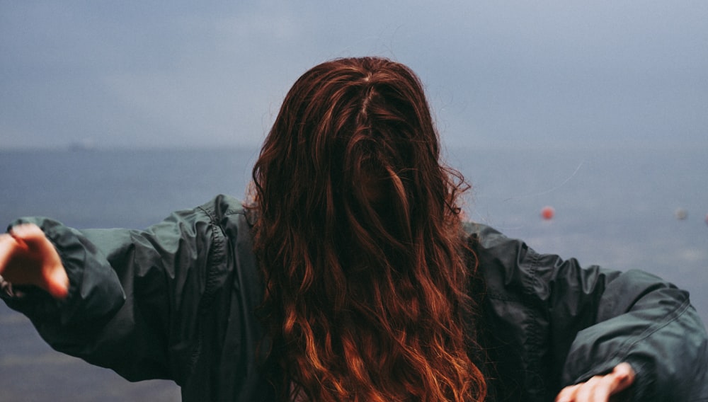 woman in gray jacket at shore