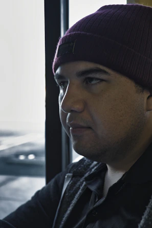 A cozy beanie resting on a wooden table with soft natural light.