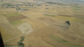 Aerial view of a patchwork of agricultural and vacant land parcels.