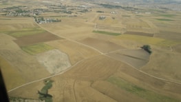 Aerial view of a patchwork of agricultural and vacant land parcels.