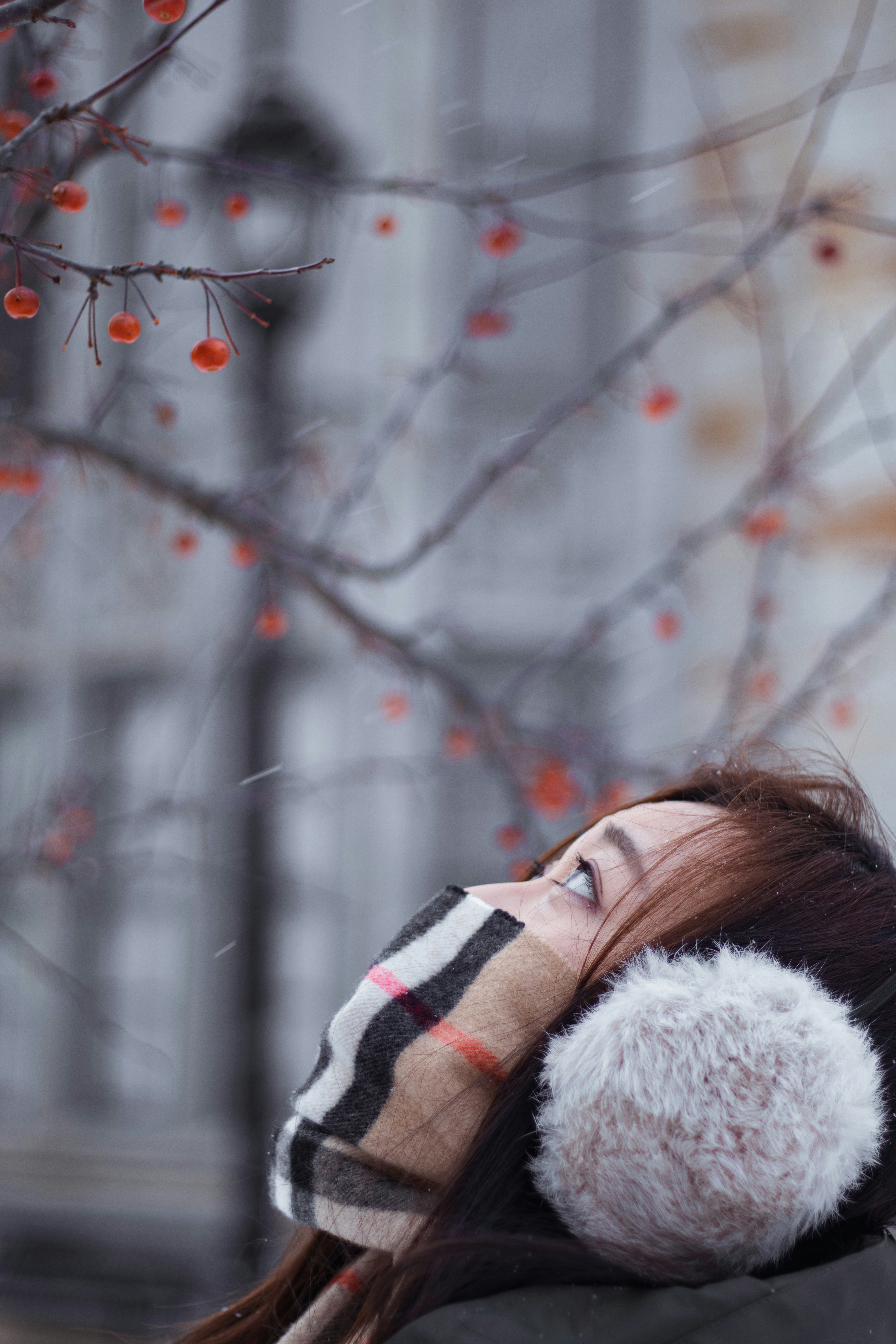 la cara de la mujer medio cubierta con tela de Burberry mientras mira hacia arriba