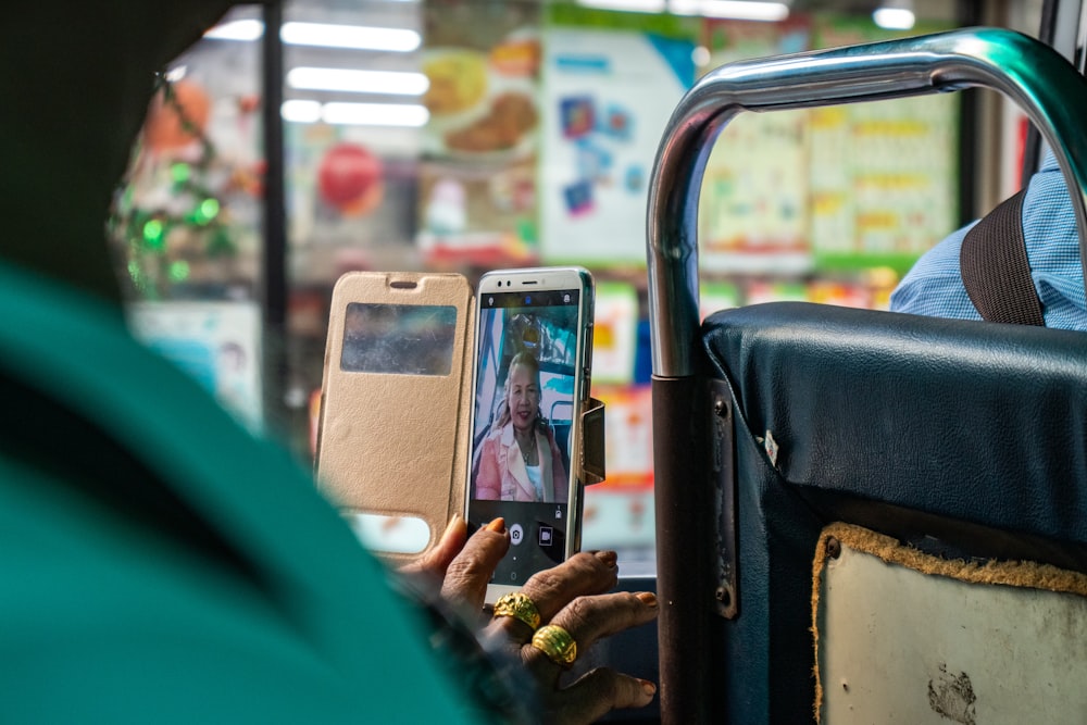 woman taking picture using smartphone inside bus