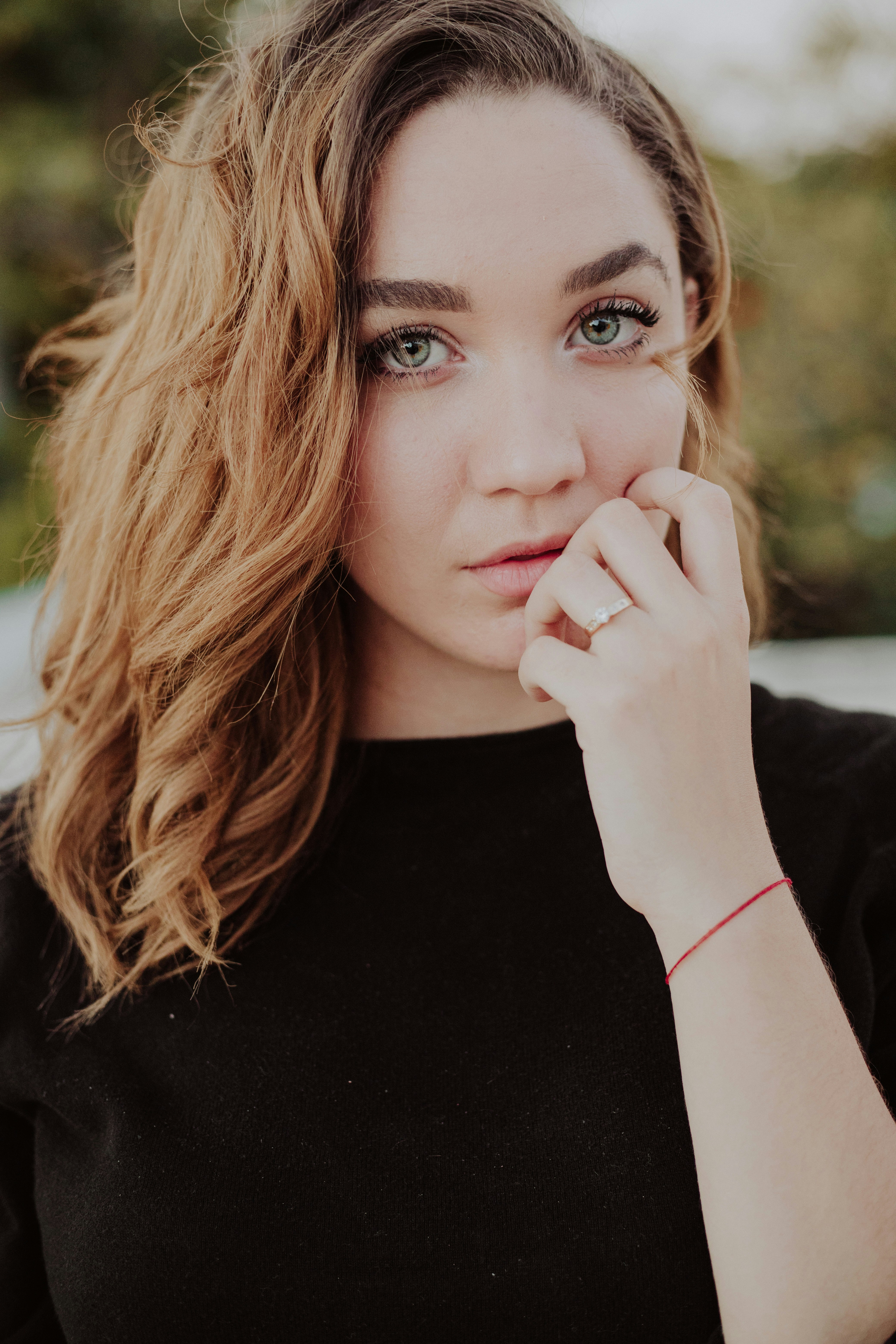 銀色の指輪をはめた黒いシャツを着た女性の浅い焦点の写真