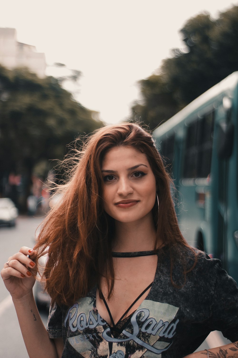 woman wearing black and gray top touching hair