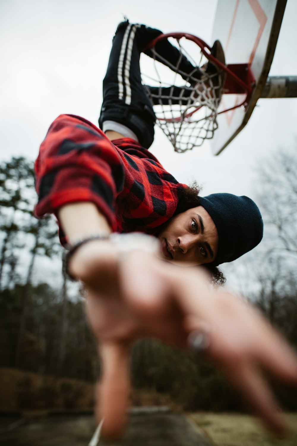 Homem com pernas no anel de basquete durante o dia