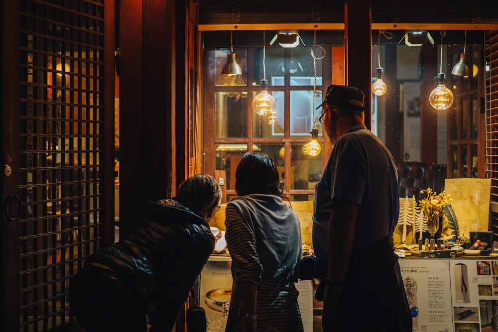 three people near glass wall