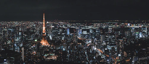 Nighttime cityscape of Tokyo with glowing lanterns and bustling streets.