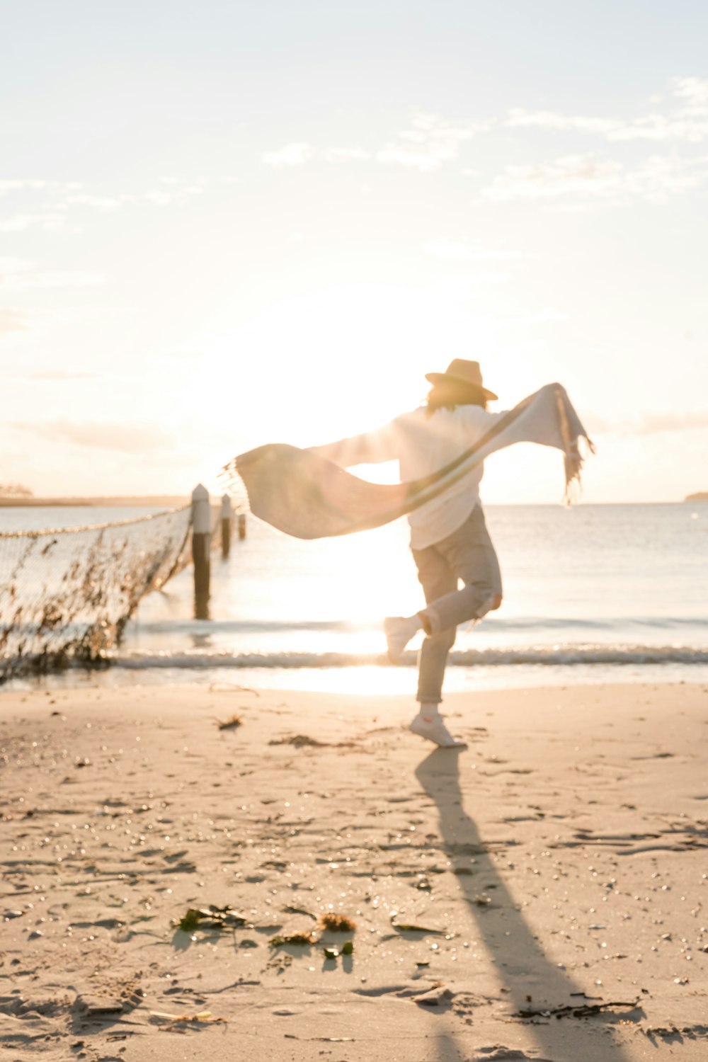 person in white sport shirt on shore during golden hour