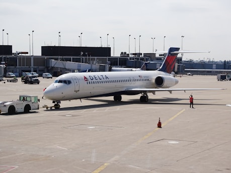 man standing beside white Delta airplane