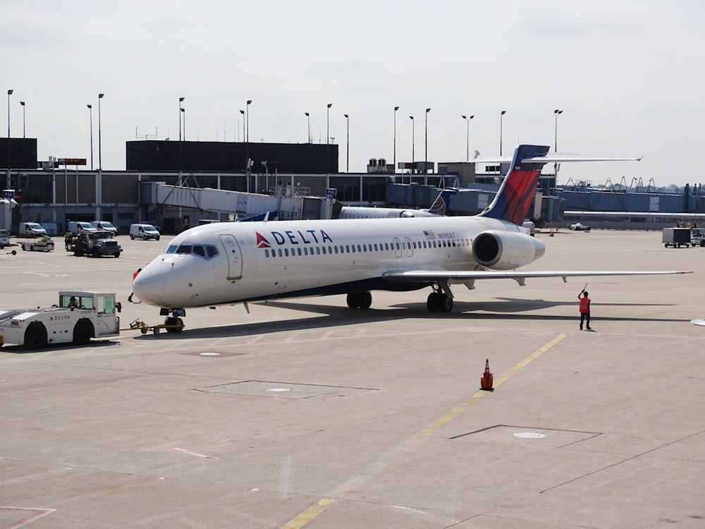 homme debout à côté d’un avion Delta blanc