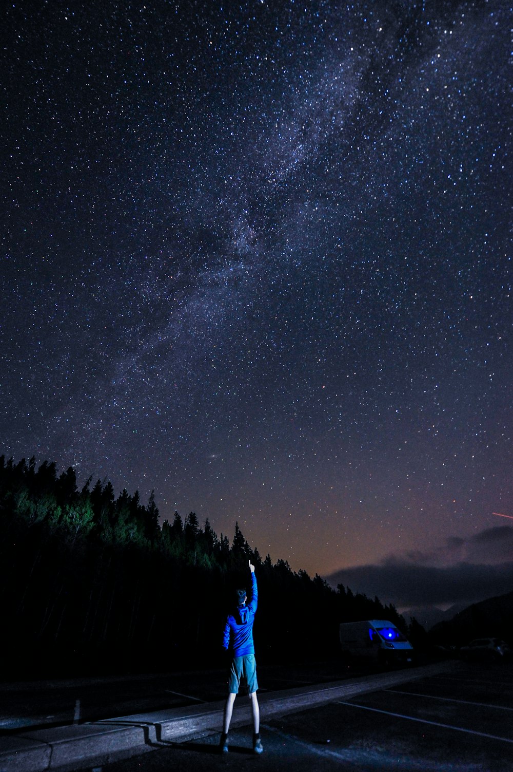 man in blue hoodie near trees at night