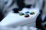 Close-up of a gamer’s hands on a colorful video game controller.