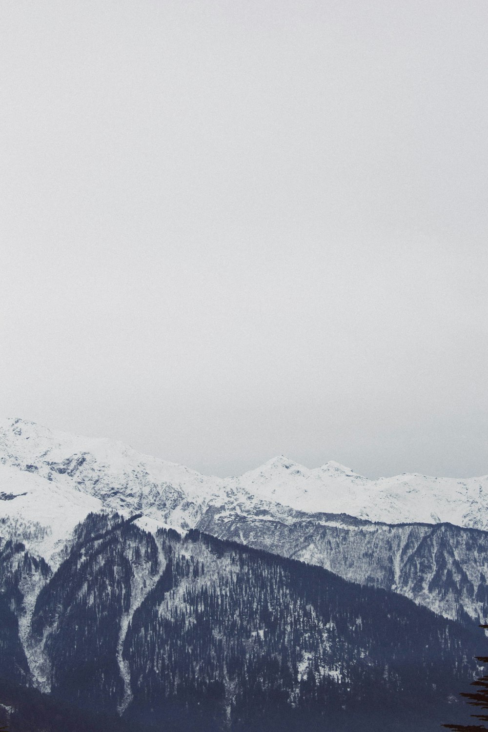 montaña gris bajo el cielo blanco