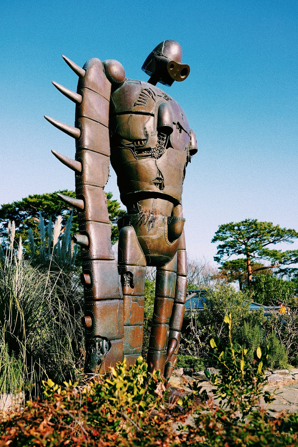 robot statue surround with flowers during datyime