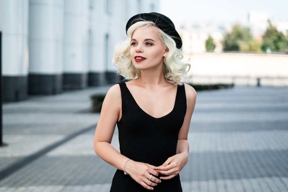 woman wearing black sleeveless top and black cap facing left