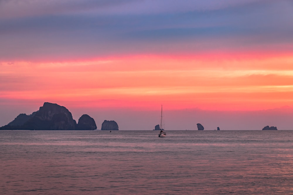 brown cliff near body of water under orange sky