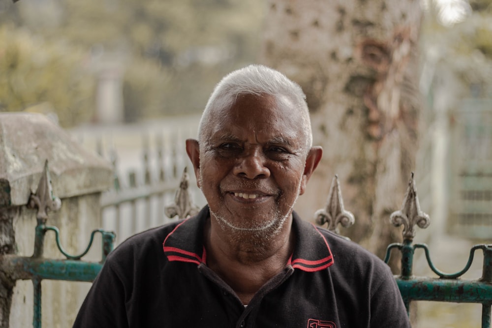 man wearing black and red polo shirt across steel gate